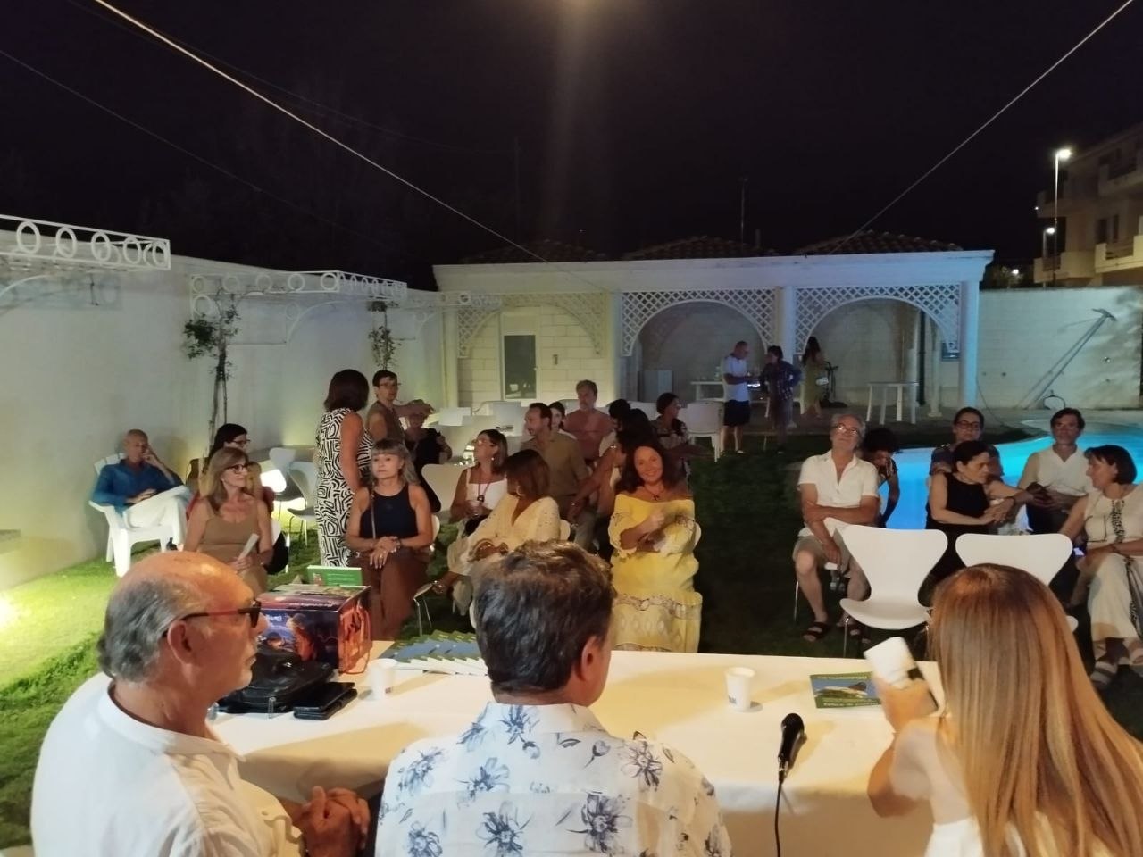 I partecipanti seduti tra le sedie del giardino estivo durante l'evento